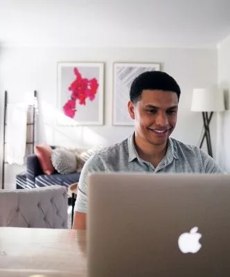 man smiles at computer
